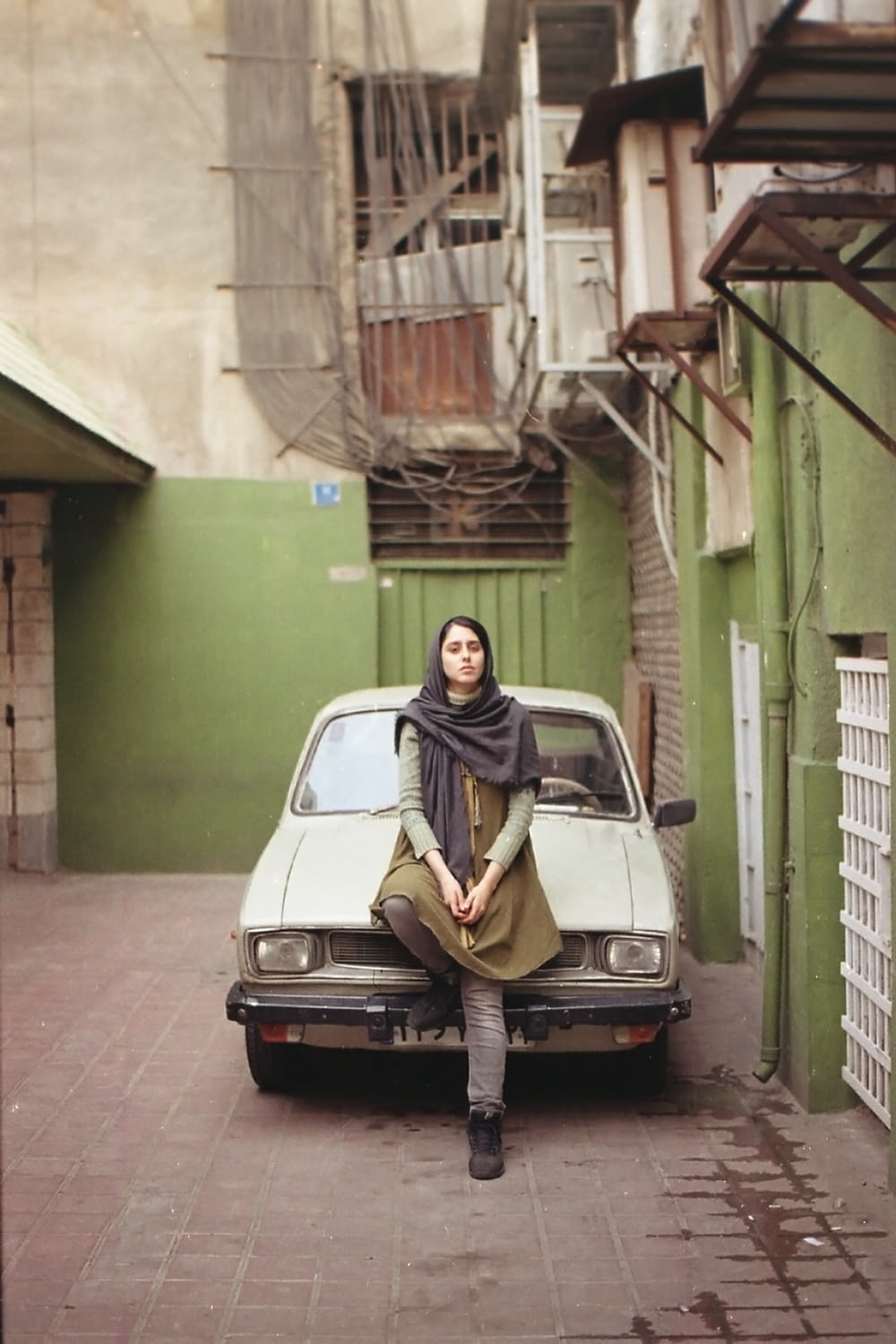 woman in black hijab standing beside white car