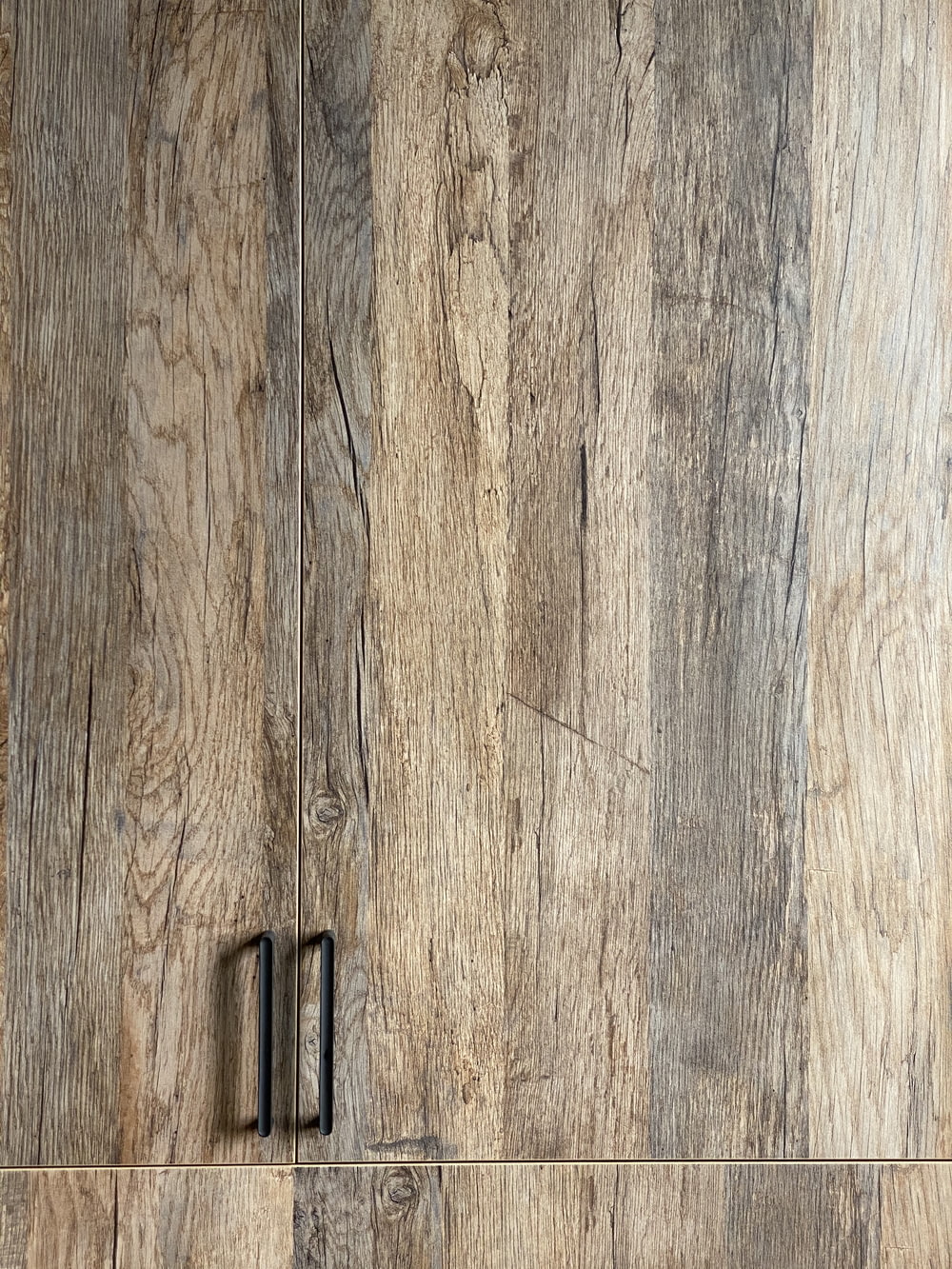 black metal door hinge on brown wooden surface