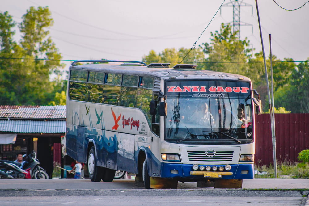 blue and white bus on road during daytime