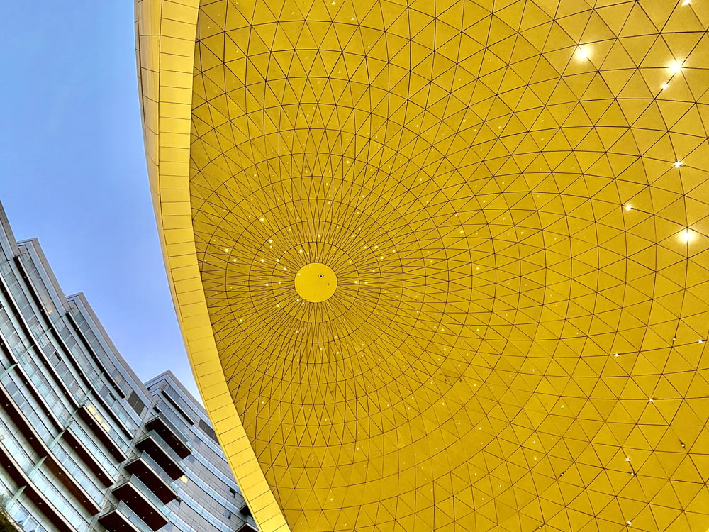 Estructura amarilla en forma de sol bajo cielo azul durante el día