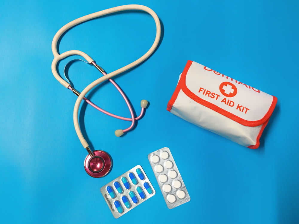 un sacchetto di pillole, uno stetoscopio e un kit di pronto soccorso