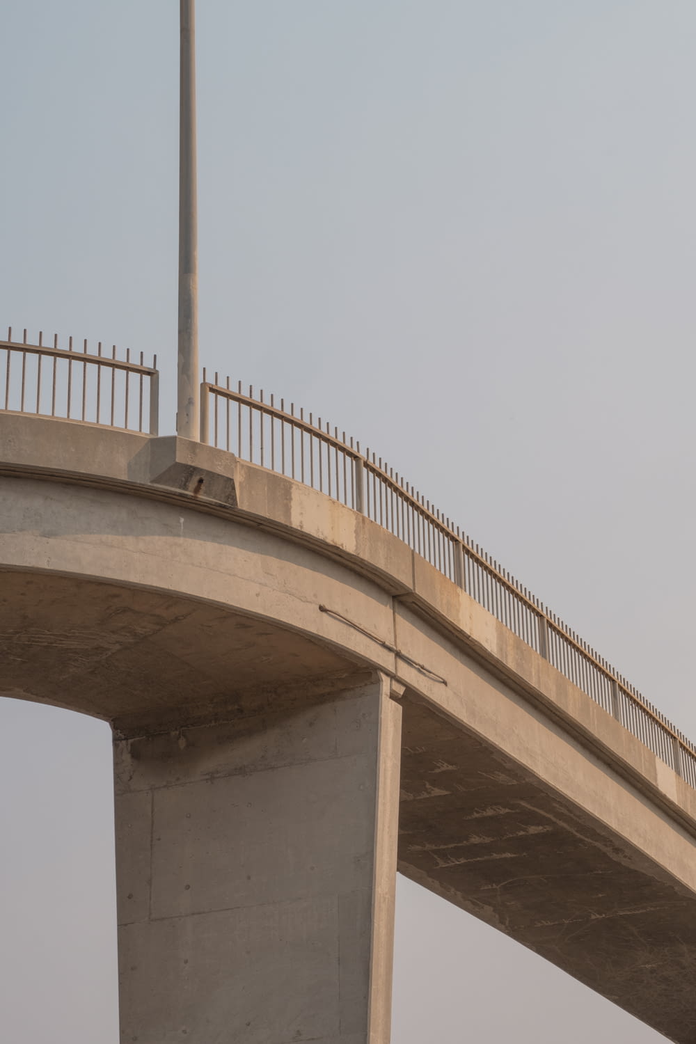 ponte de concreto marrom sob o céu branco durante o dia