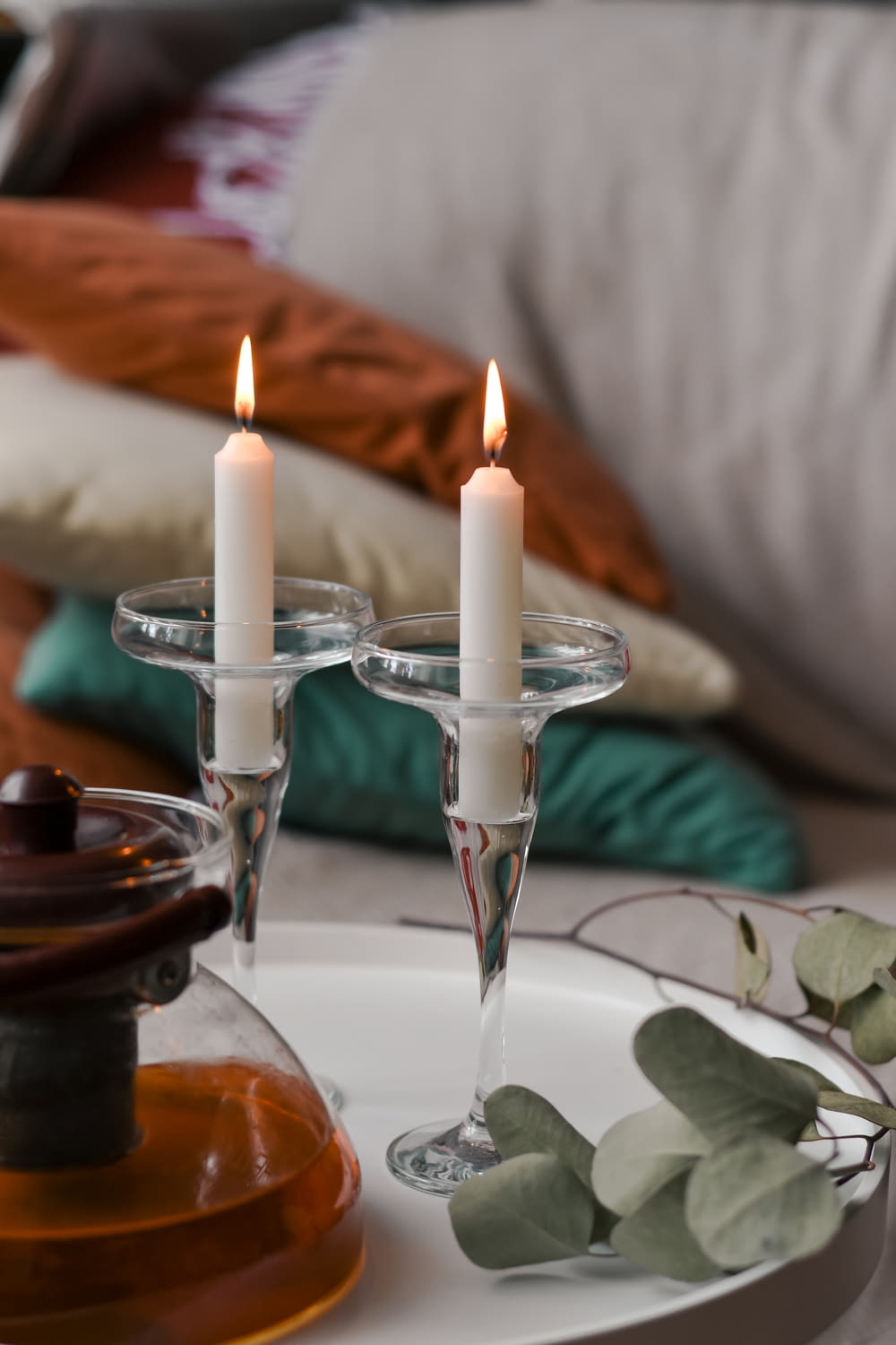 white candles on clear glass candle holder