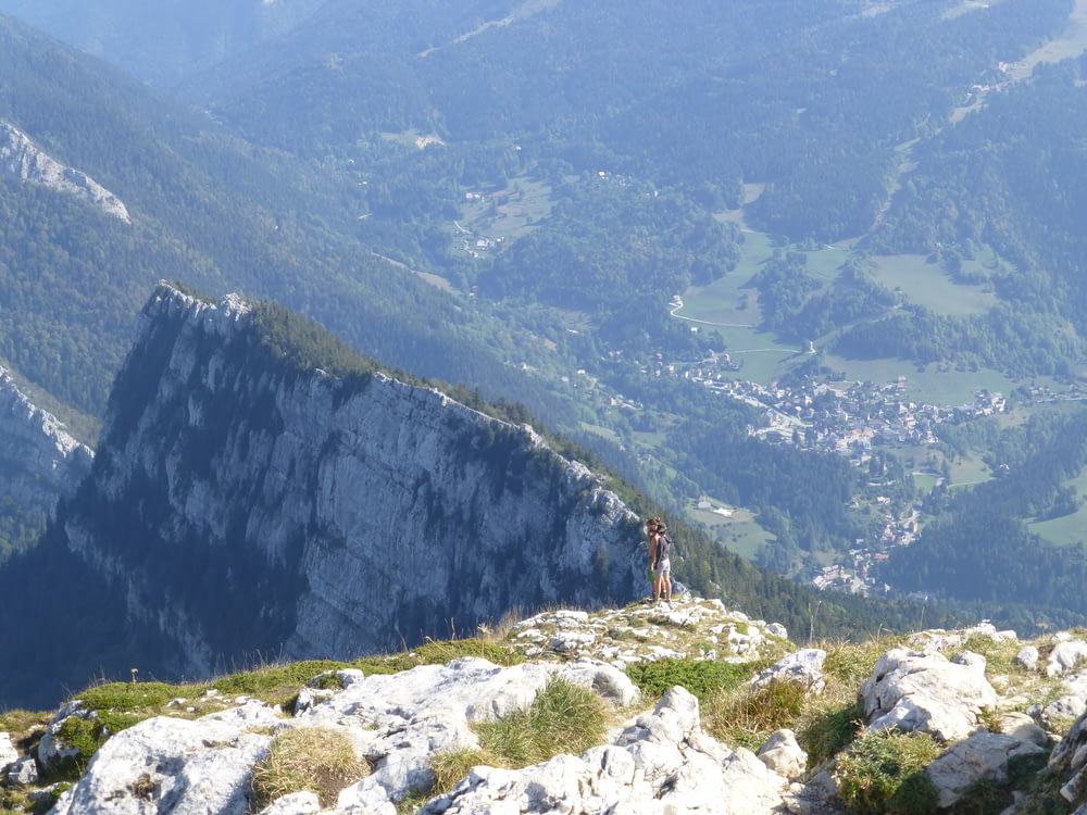 pessoa em pé na montanha de rocha durante o dia