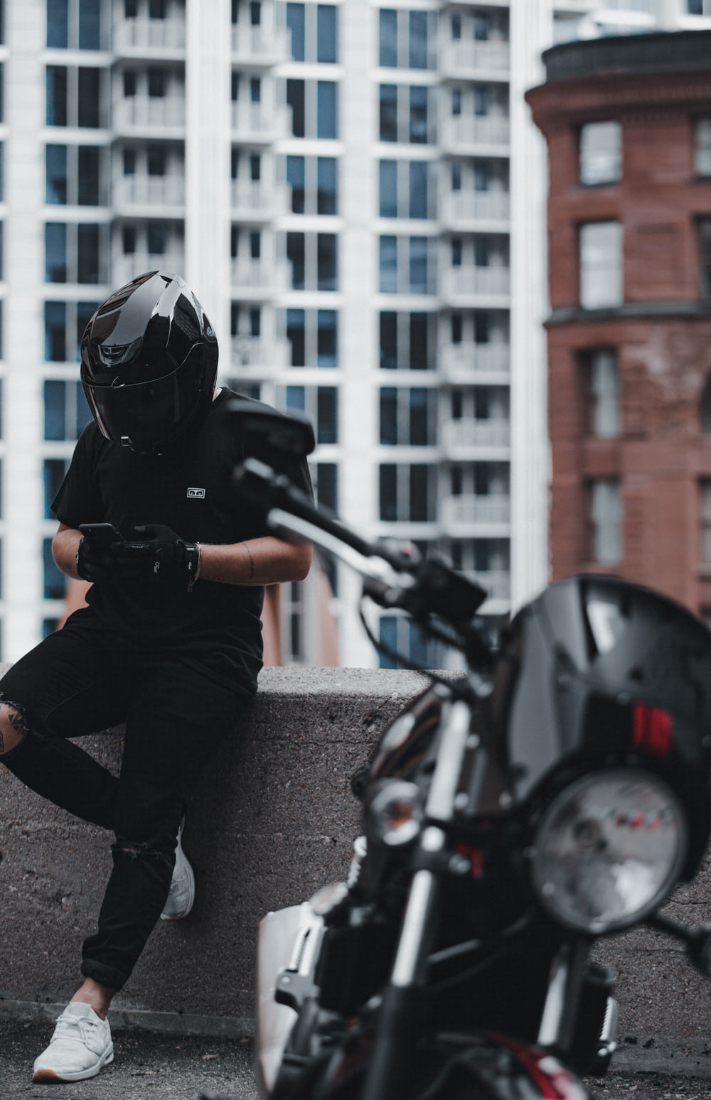 man in black jacket and gray pants wearing black helmet riding motorcycle during daytime