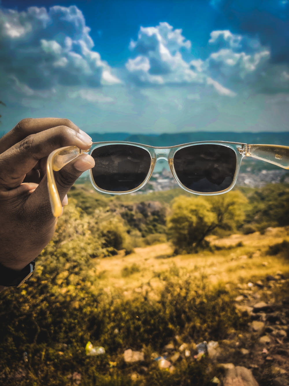 person holding white framed sunglasses during daytime