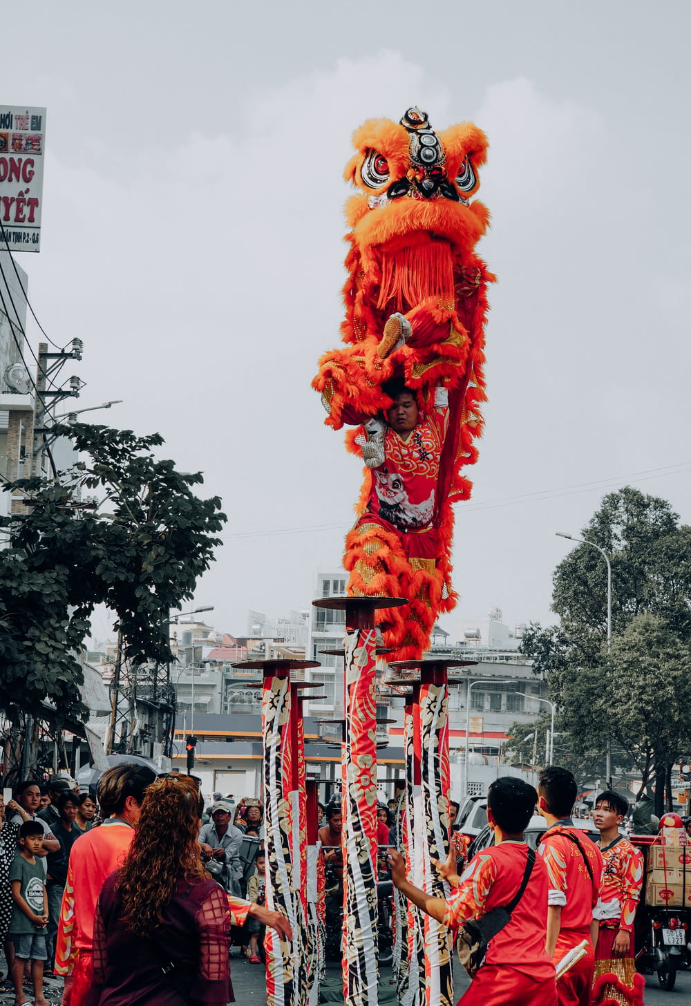 personnes marchant dans la rue avec une statue de dragon rouge pendant la journée