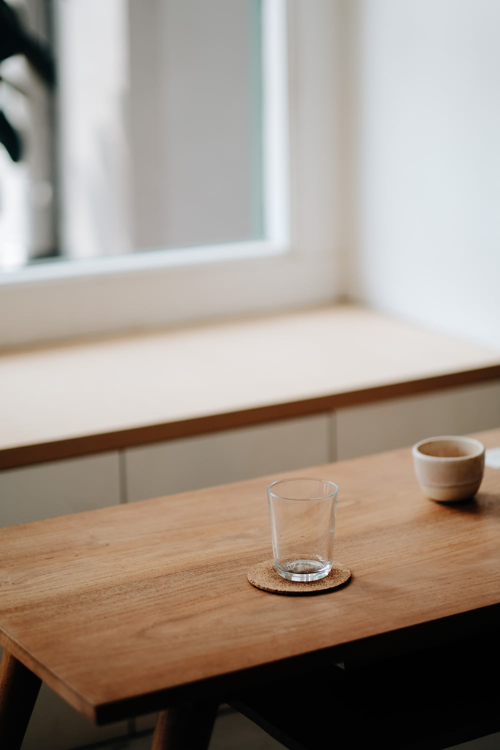 bicchiere trasparente su tavolo in legno marrone