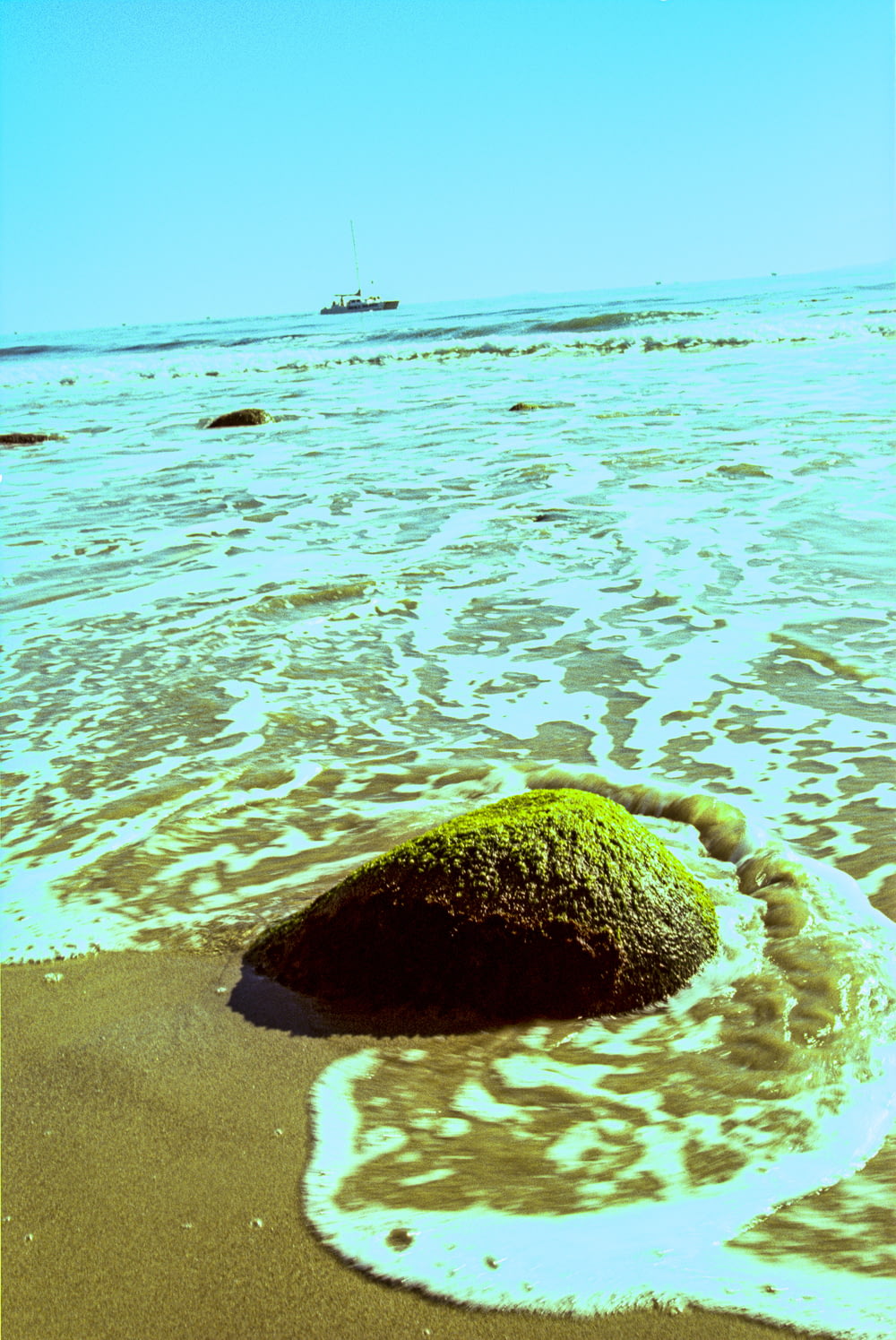 roccia marrone sull'acqua blu del mare durante il giorno