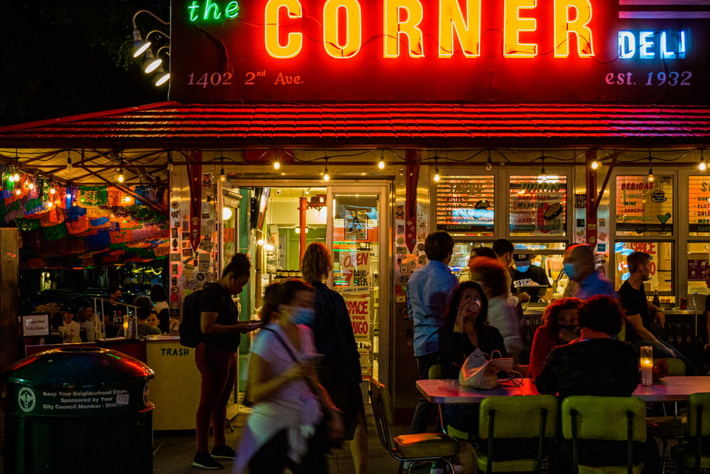 people sitting on chair in front of store during night time