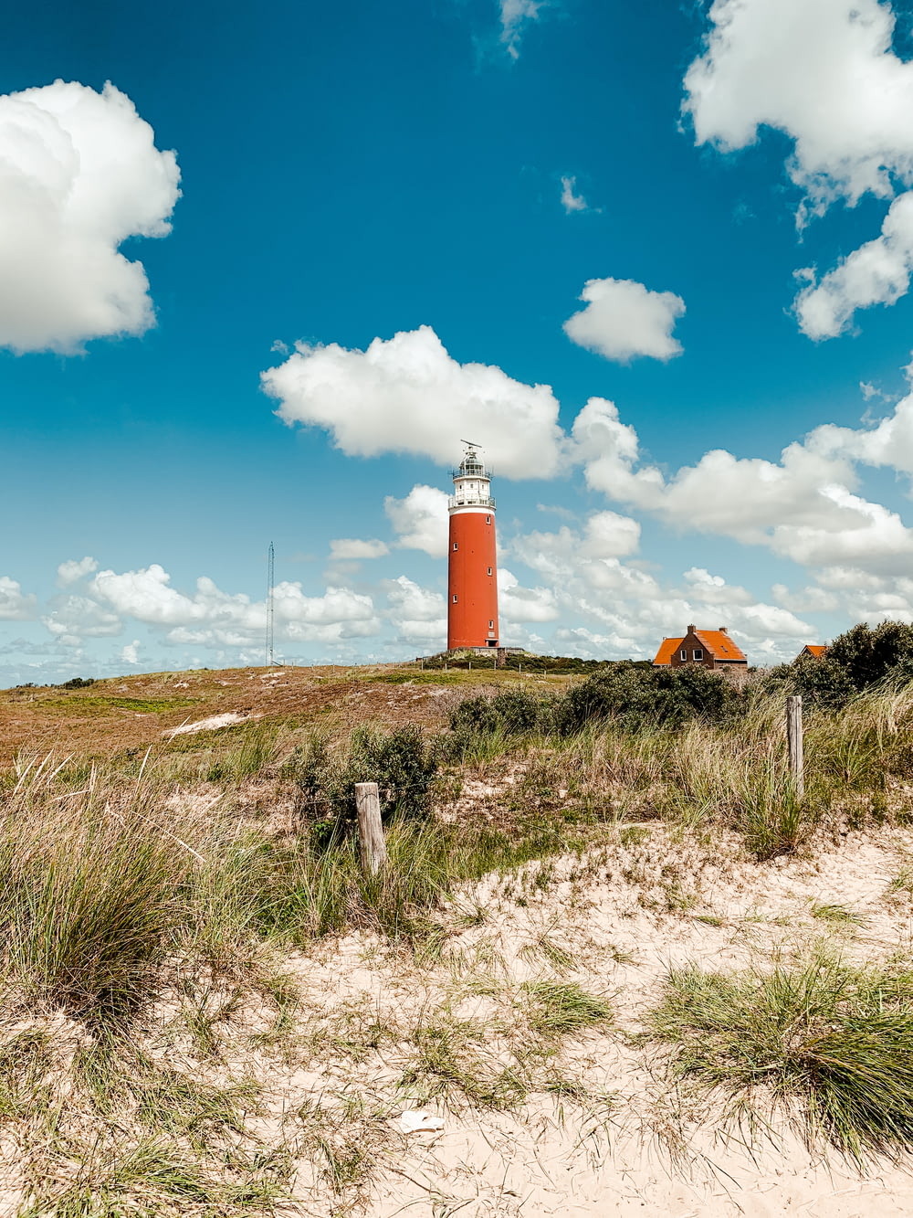 orange and white lighthouse under blue sky during daytime