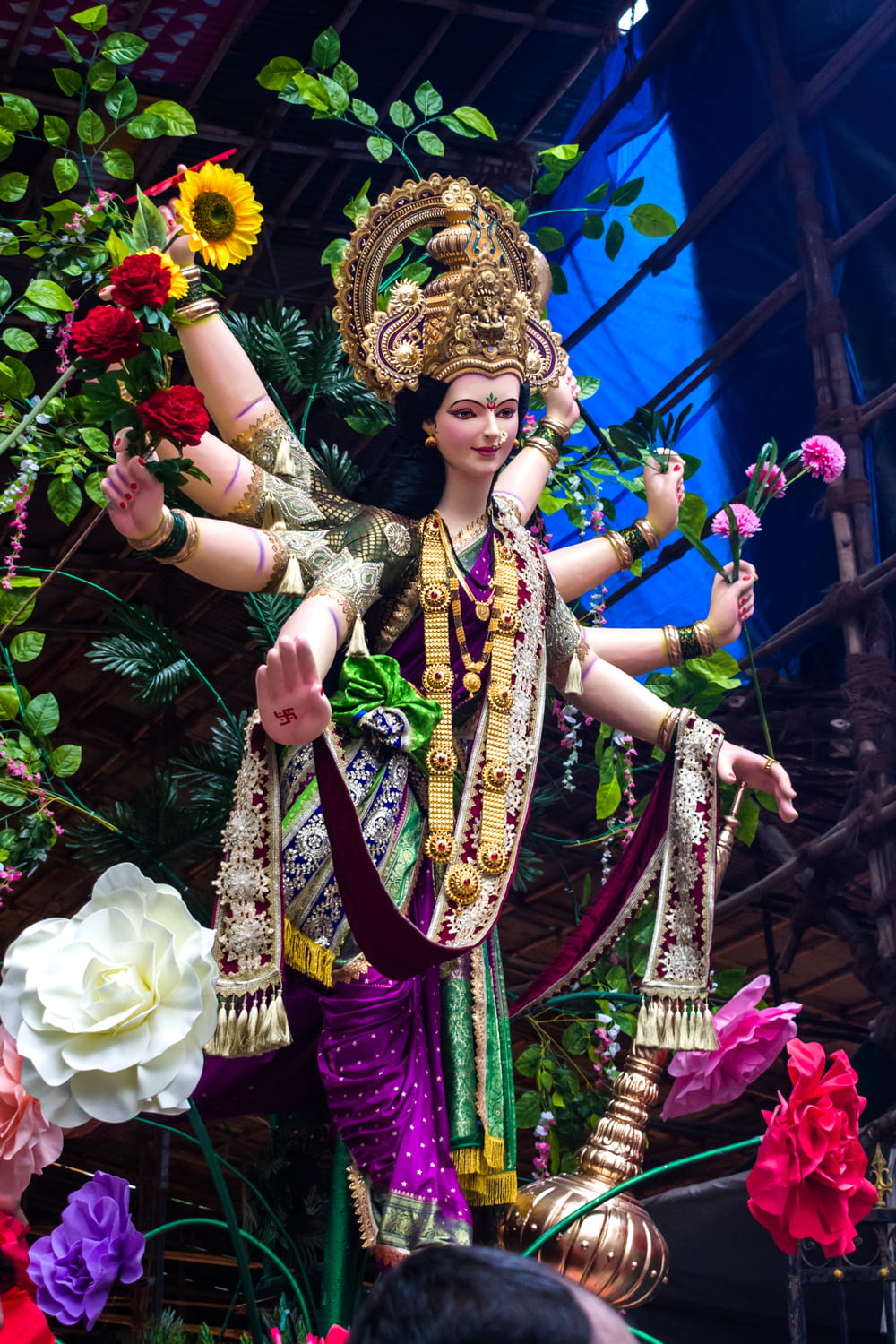 Femme en robe de sari violet et or portant une couronne d’or