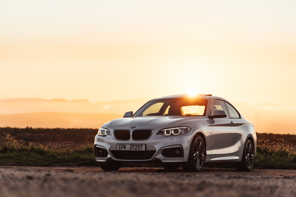 white bmw m 3 coupe on brown field during sunset