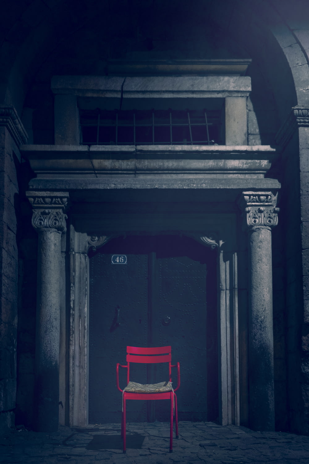 red chair in front of brown wooden door