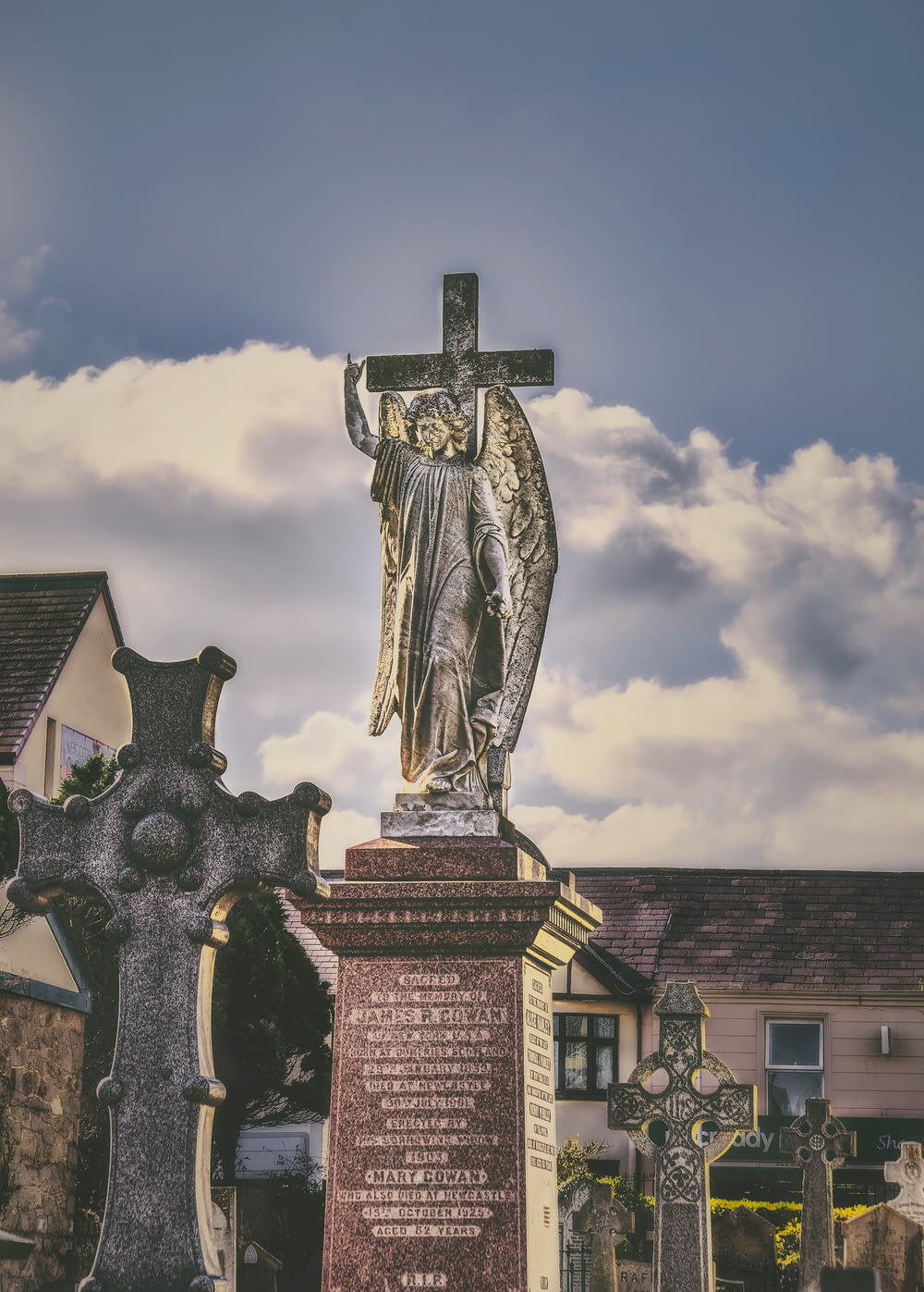 墓の上に十字架を持つ女性の像