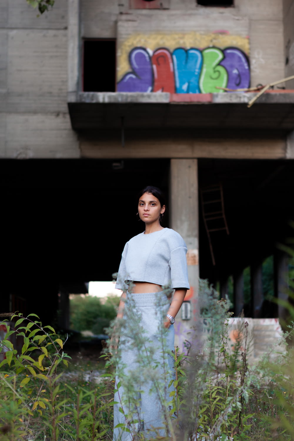 woman in white crew neck t-shirt standing near green plants during daytime