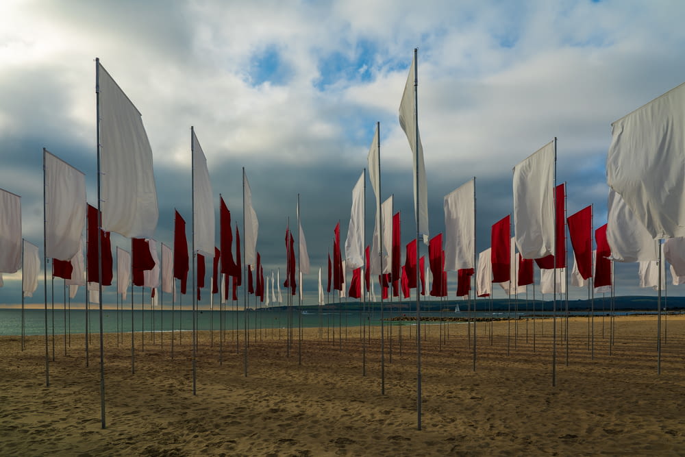 bandiere sulla recinzione metallica grigia sotto nuvole bianche durante il giorno