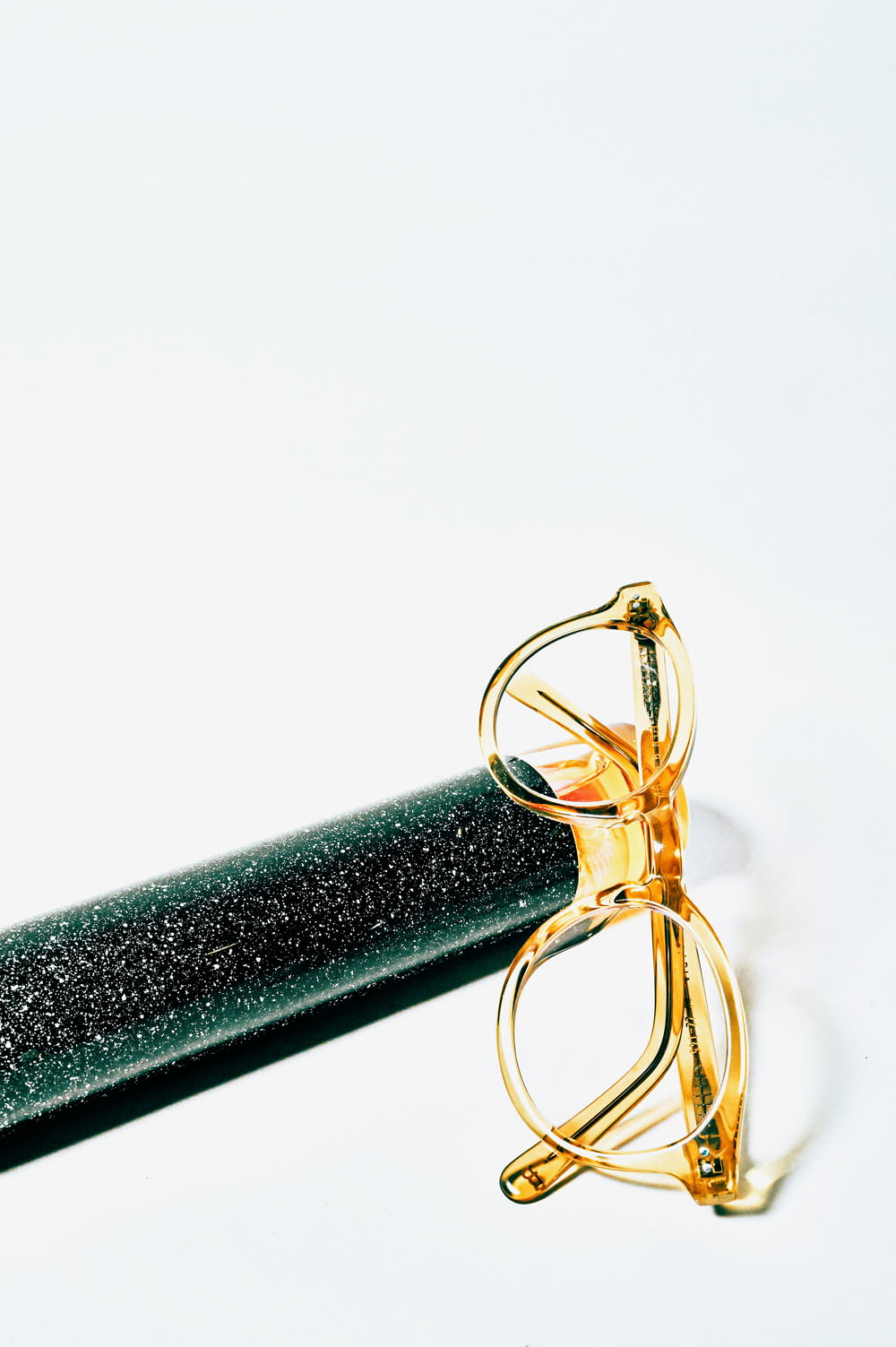 gold framed eyeglasses on black tube