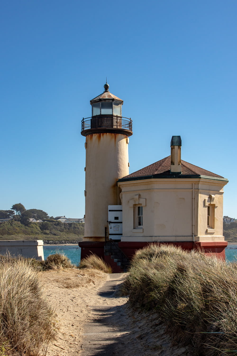 white and brown concrete lighthouse near body of water during daytime
