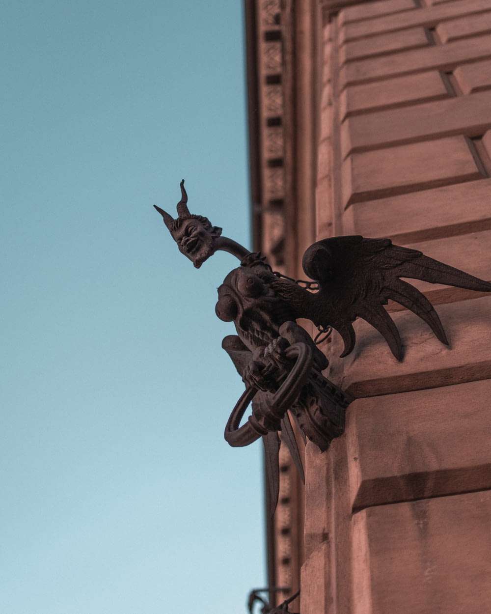 Statue de dragon noir sur un bâtiment en béton brun pendant la journée