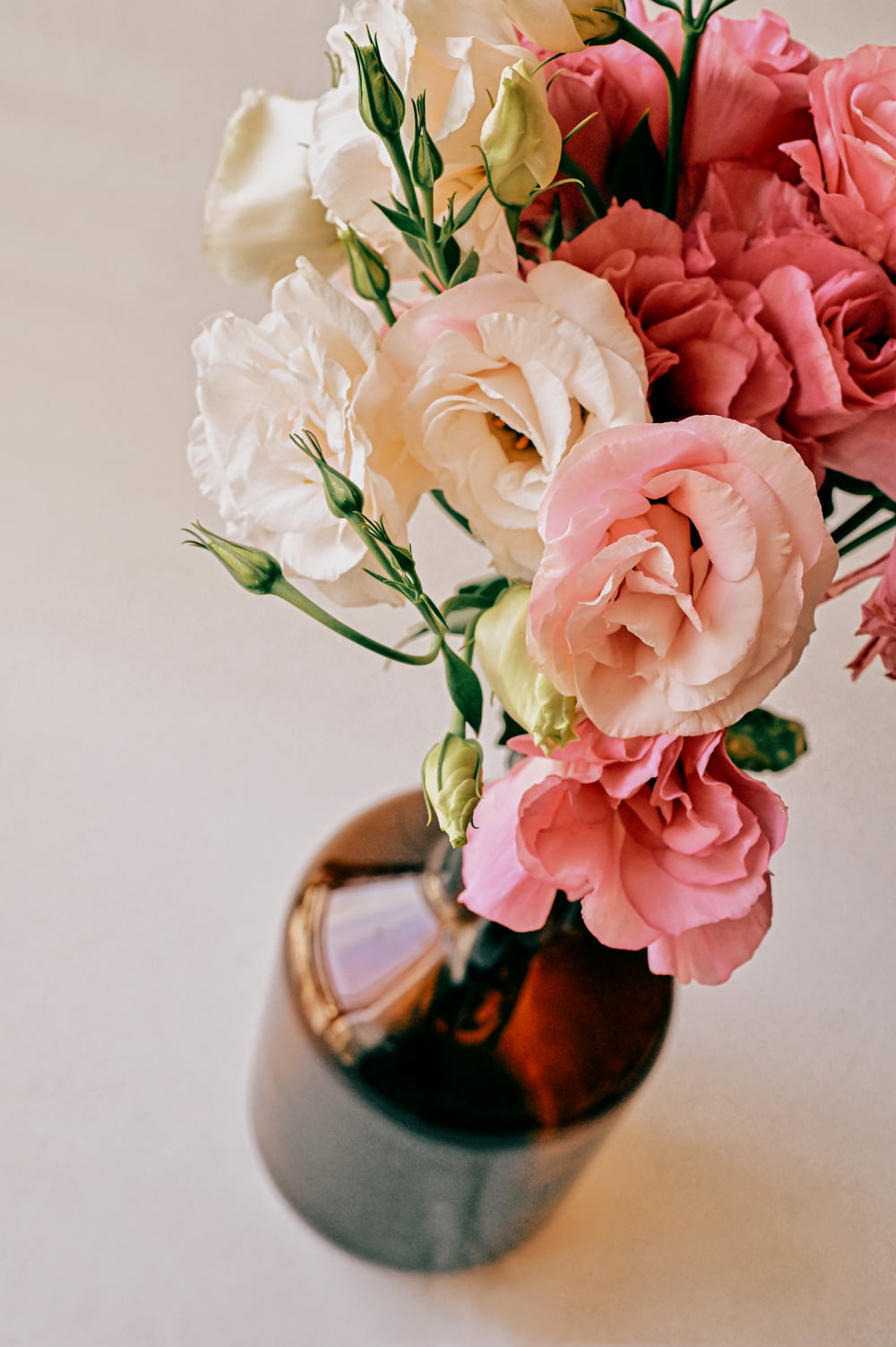 pink and white roses in brown vase