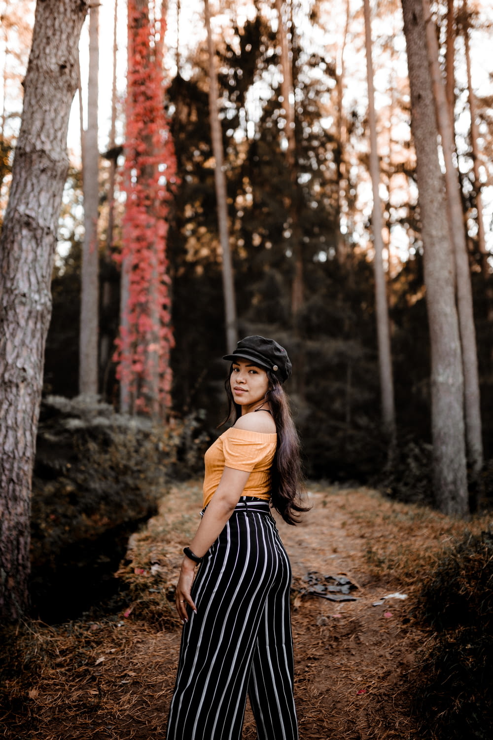 woman in black and white striped dress standing in forest during daytime
