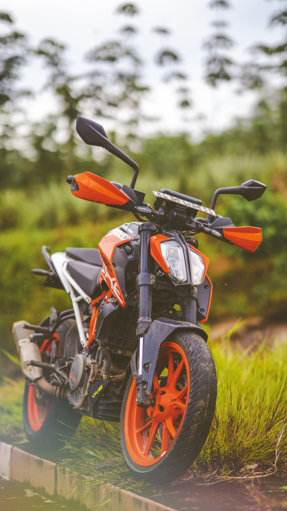black and orange motorcycle on green grass during daytime