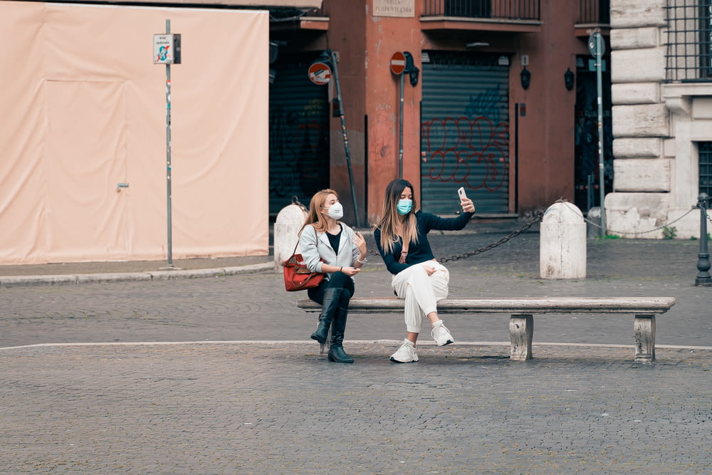 3 donne che si siedono su una panchina di cemento