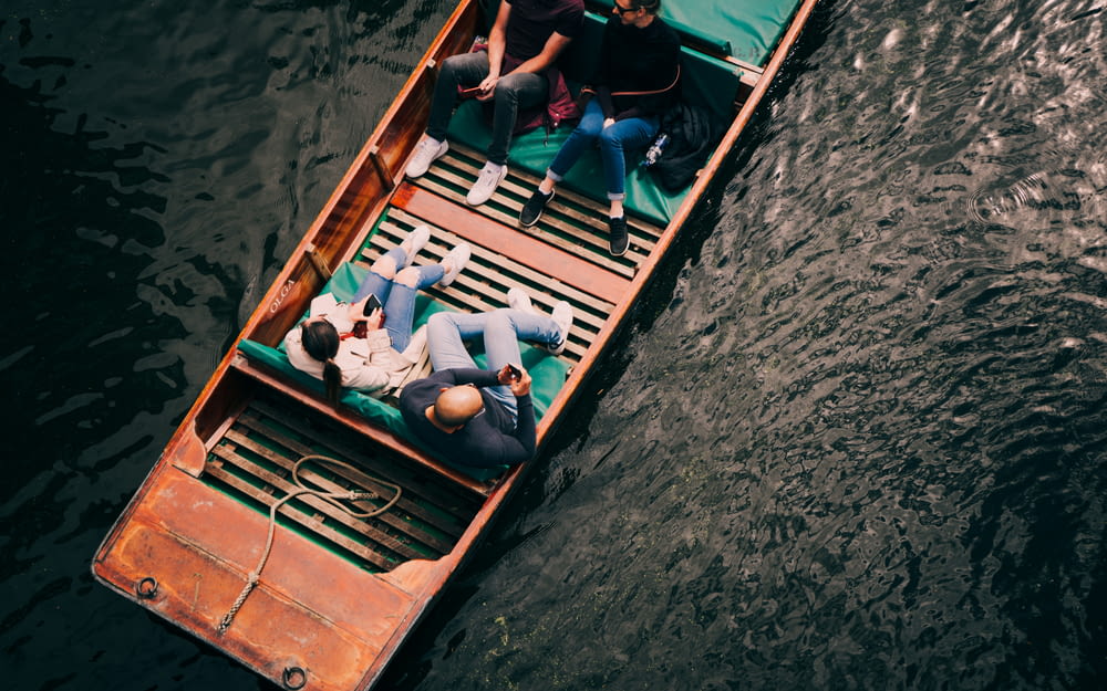 people in blue and black shirt riding on boat during daytime