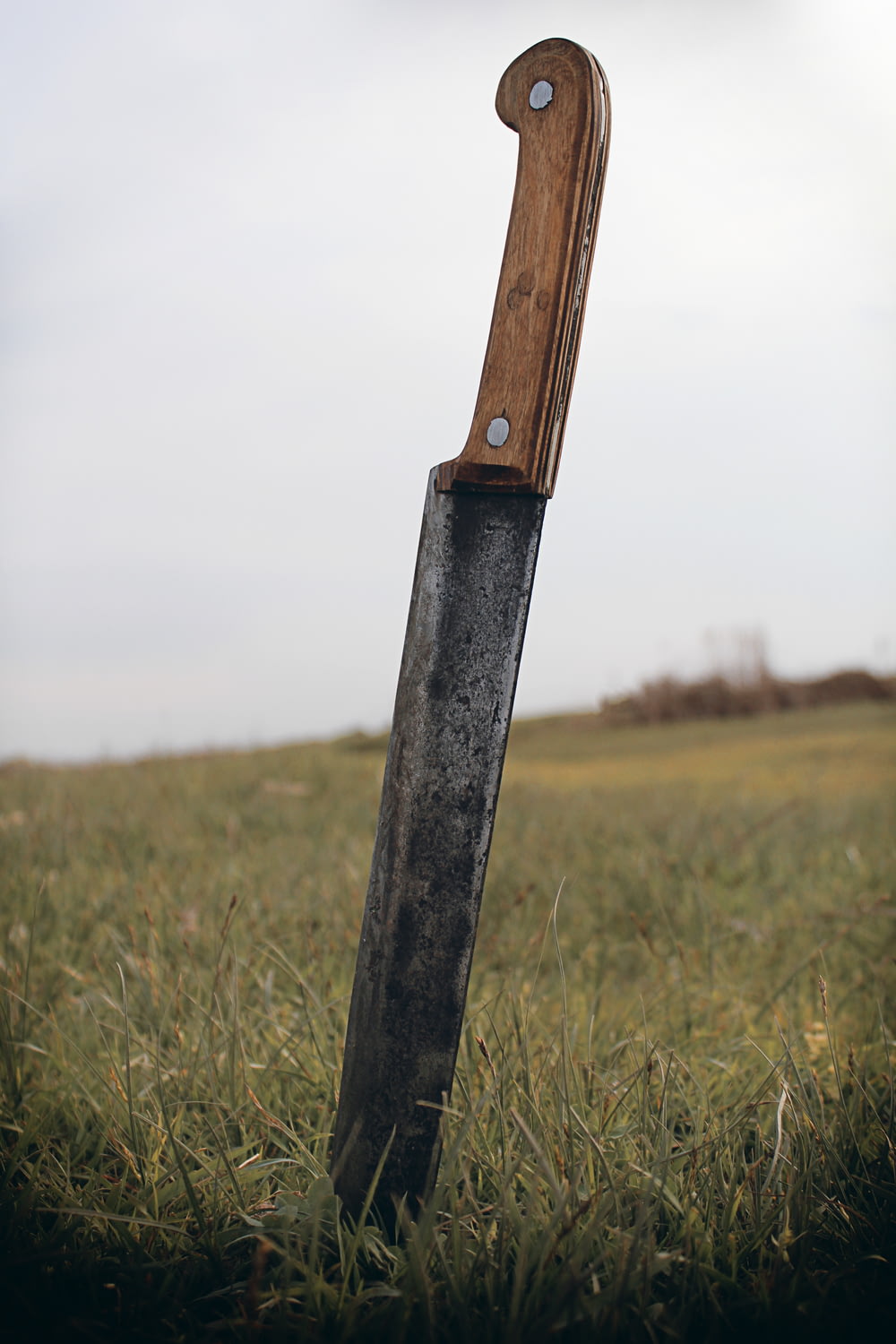 black handle knife on green grass field during daytime