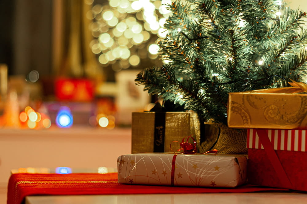 Caja de cartón marrón al lado del árbol de Navidad verde