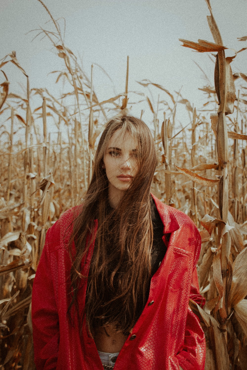 Frau in rotem Schal mitten im Weizenfeld
