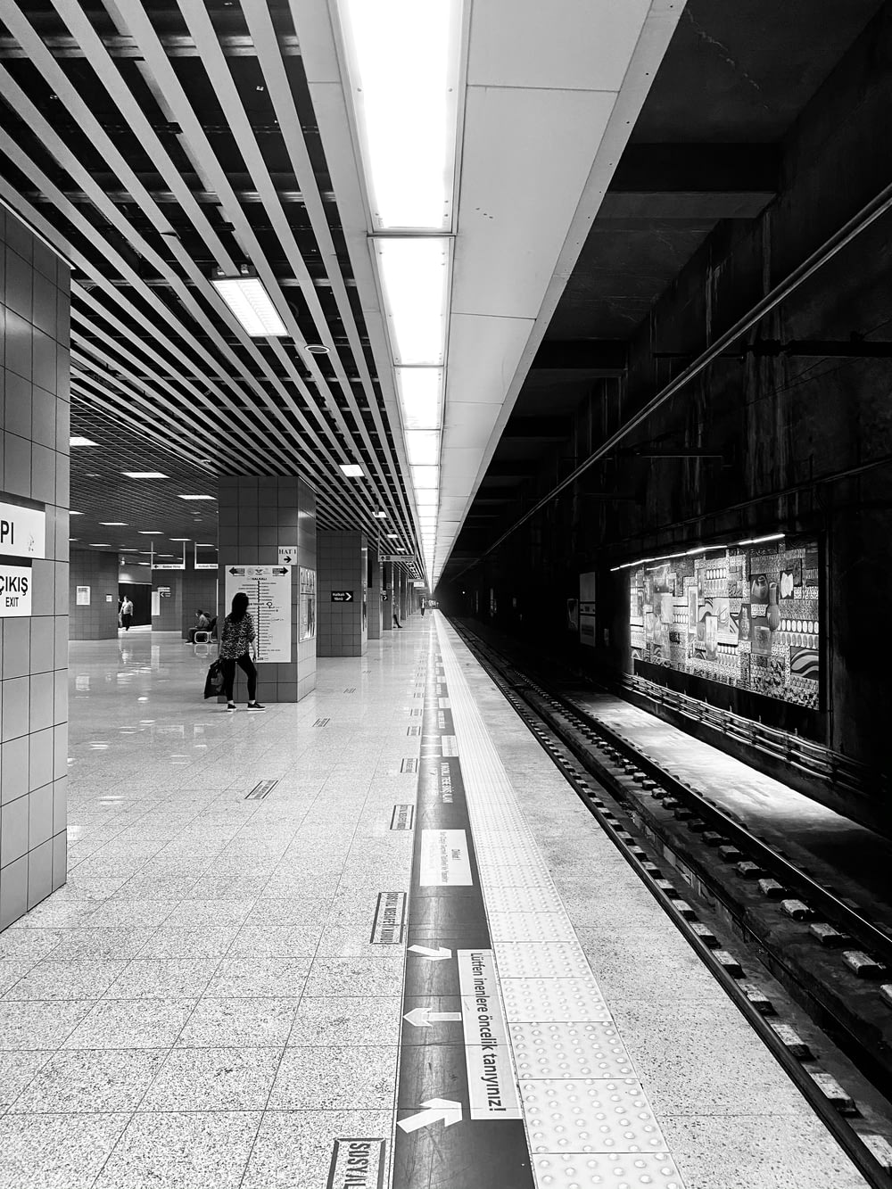 기차역을 걷는 사람들의 그레이스케일 사진