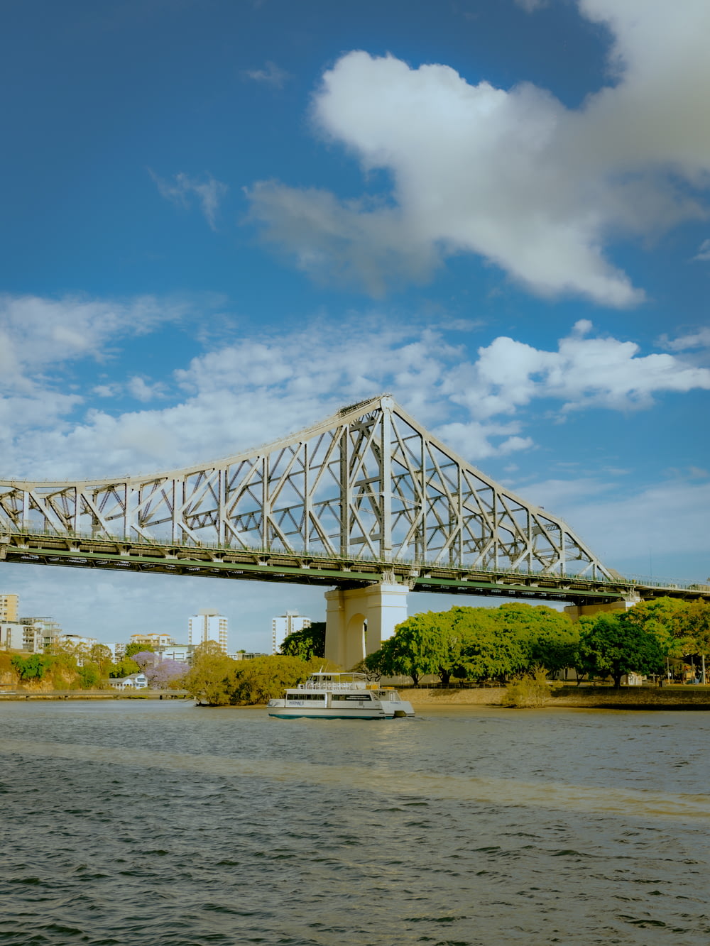 white metal bridge over river under blue sky during daytime