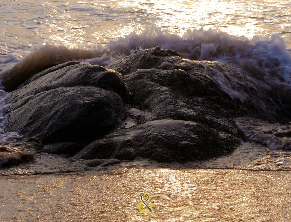 black rock formation on seashore during daytime