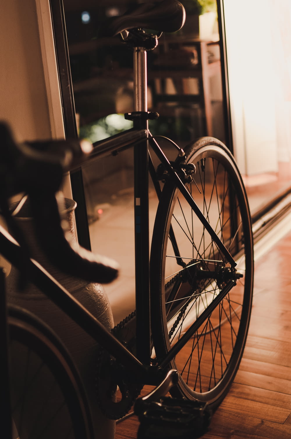 grayscale photo of bicycle near window