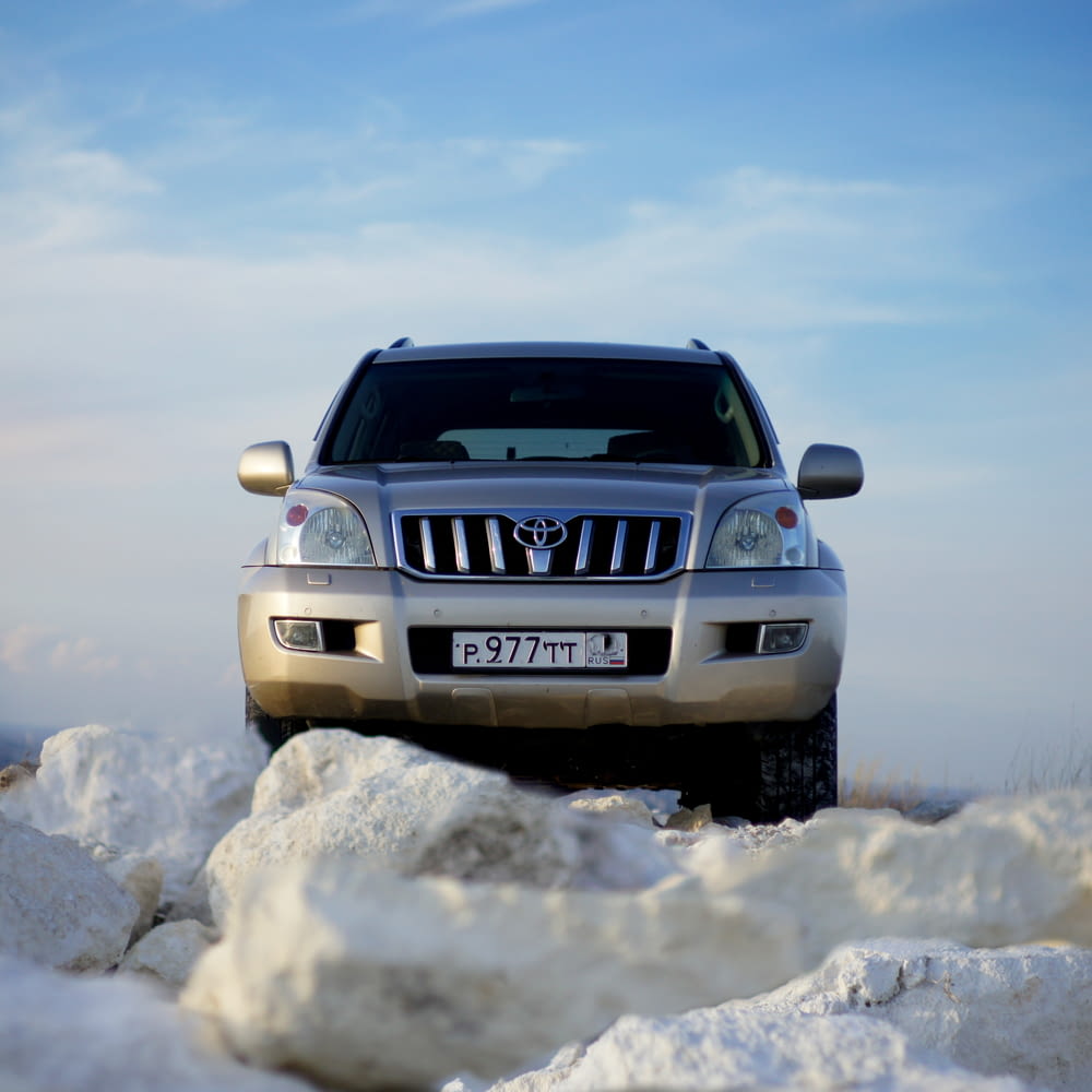 white nissan suv on snow covered ground under blue sky during daytime