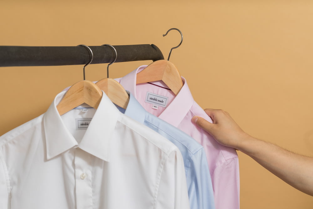 white button up shirt on brown clothes hanger