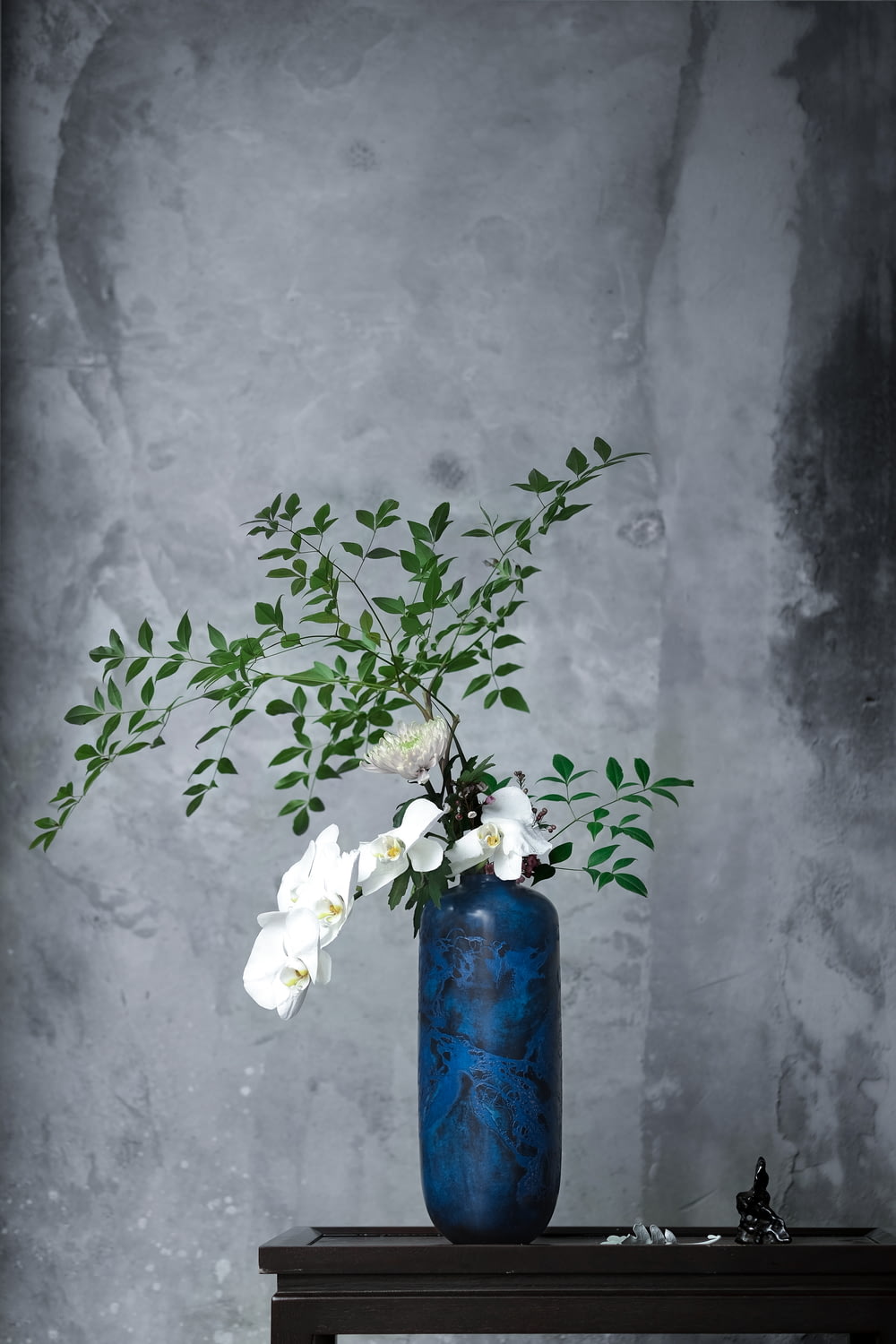 white flowers in blue vase