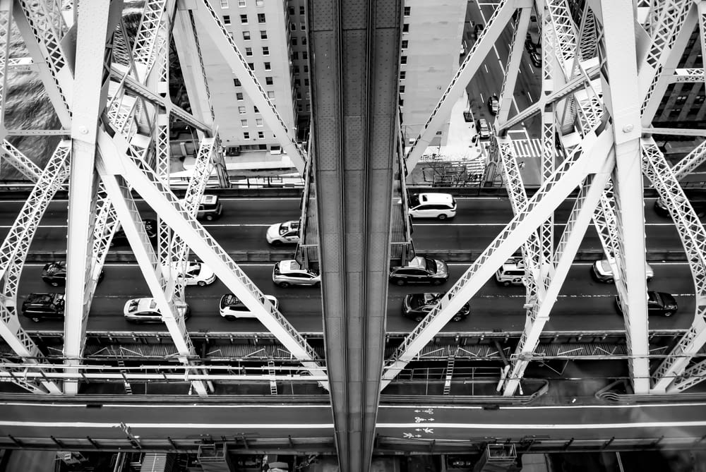 white and black cars on gray metal bridge