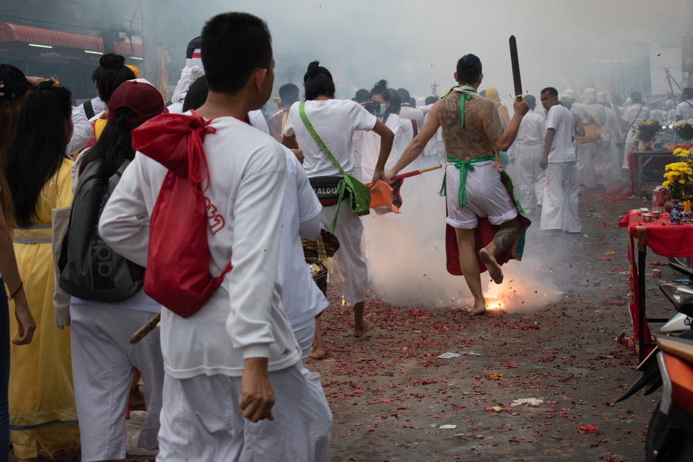 people in white uniform holding green stick during daytime