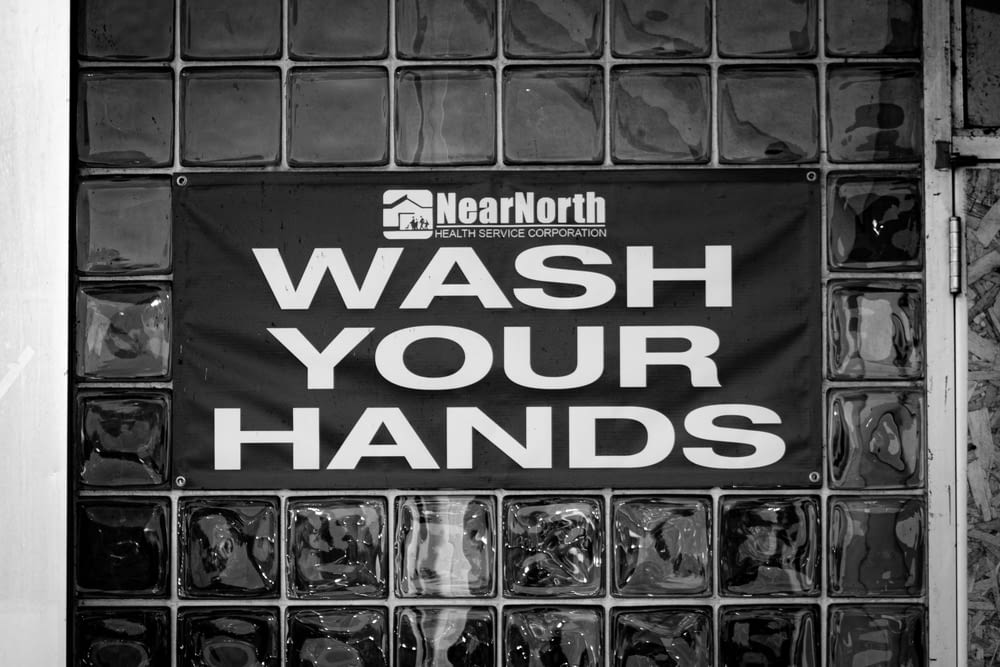 a black and white photo of a wash your hands sign