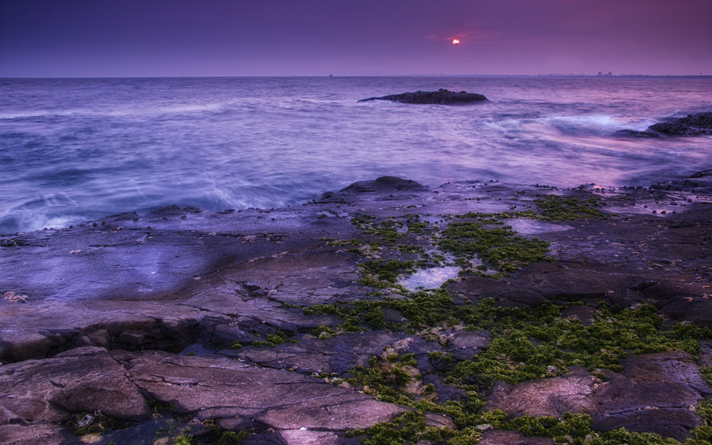 ocean waves crashing on rocks during sunset