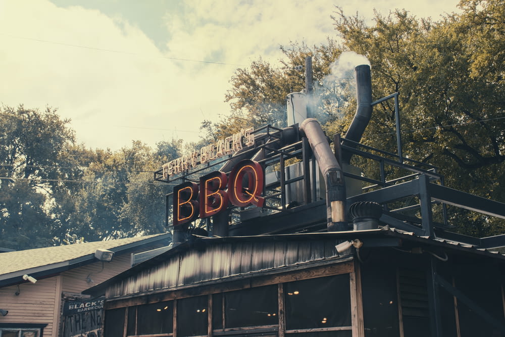 a bbq sign on top of a building with smoke coming out of it