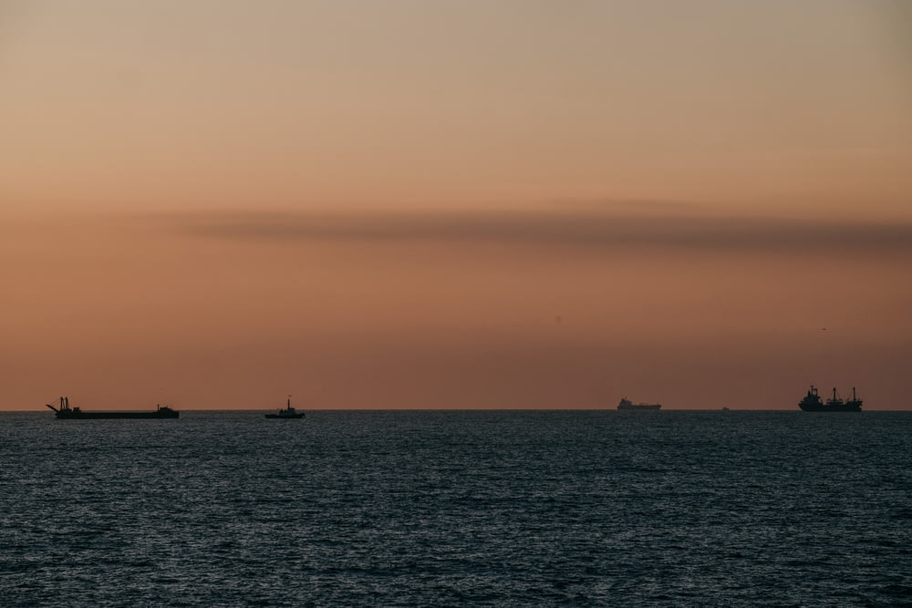 Silhouette de voilier sur mer au coucher du soleil