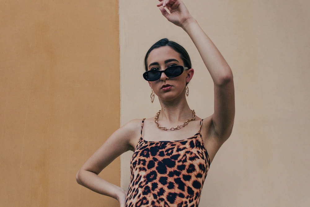 woman in brown and white leopard print tank top wearing black sunglasses