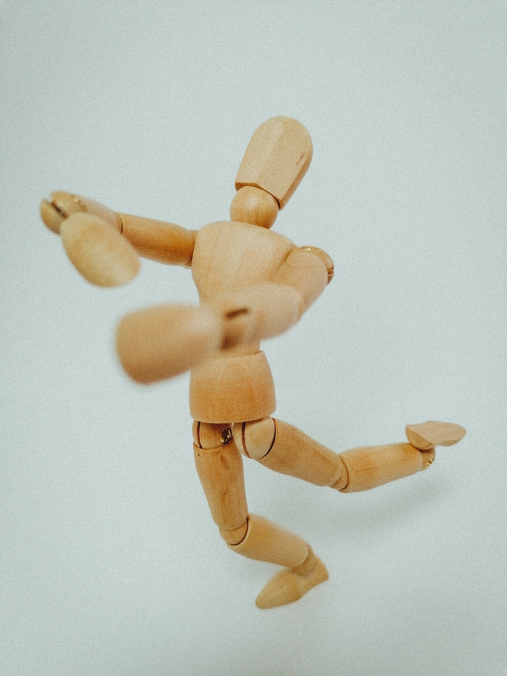 brown wooden human figure on white surface