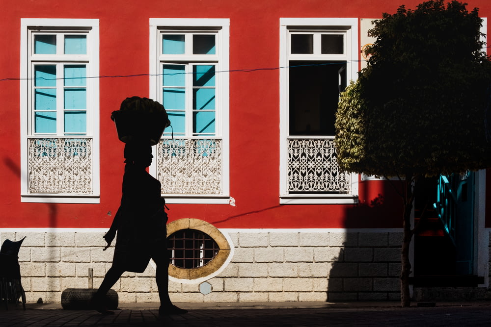 Estatua del perro negro cerca del edificio rojo durante el día