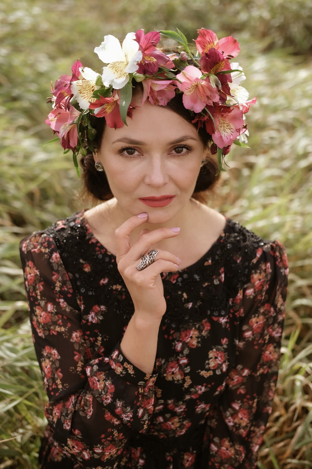 woman in black and red floral dress with pink flower on her ear