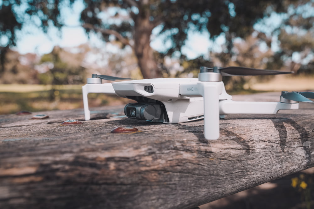 white and black drone on brown wooden table